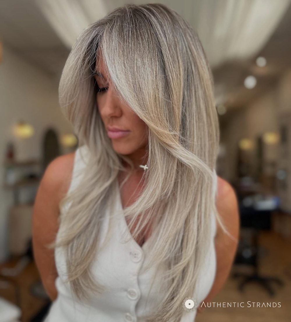 Long wavy blonde balayage with a soft root, styled at Authentic Strands in Grandview Heights