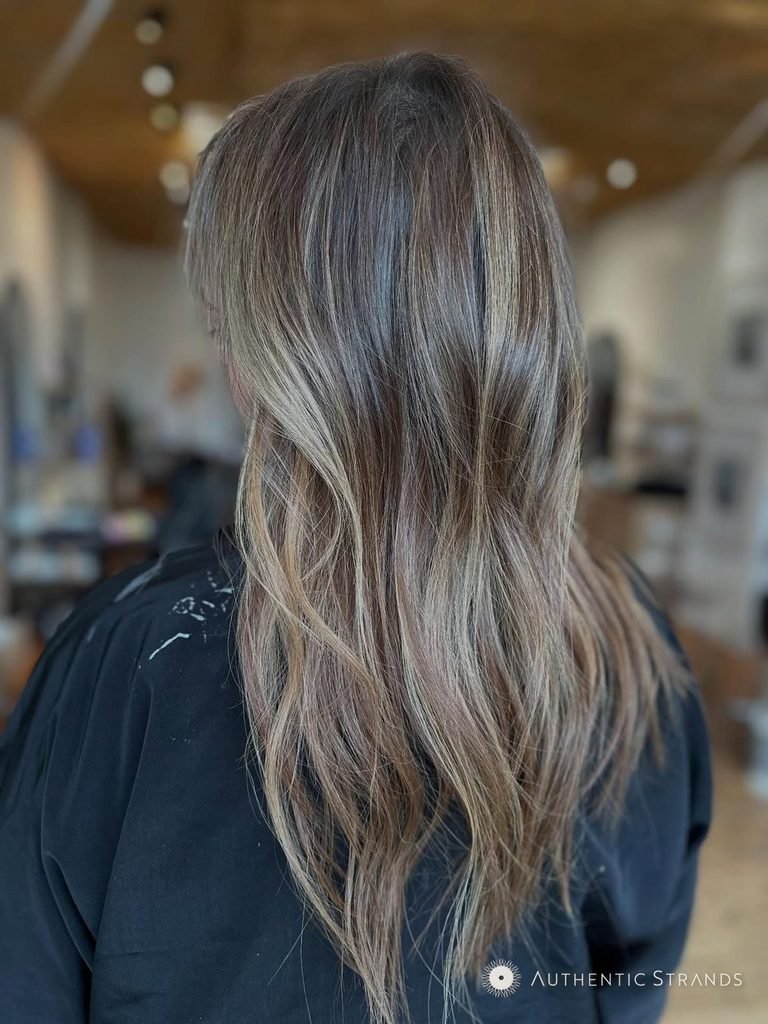 Back view of long dimensional bronde hair with blended lighter and darker pieces