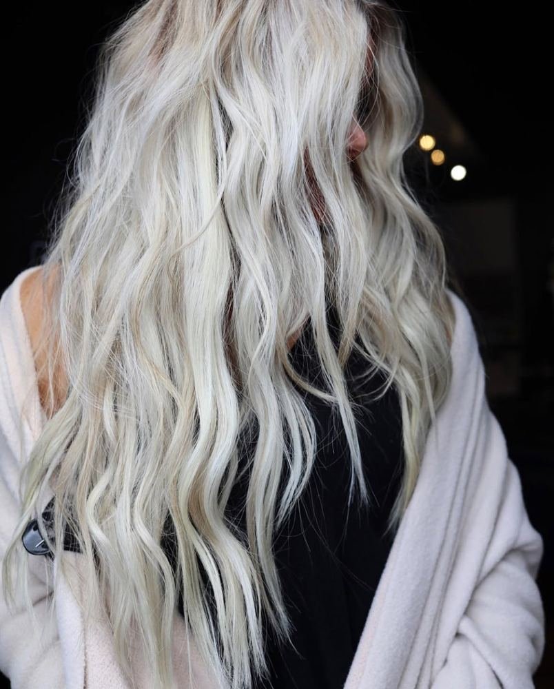 Long wavy icy blonde hair with a cool, toned finish, shown from behind