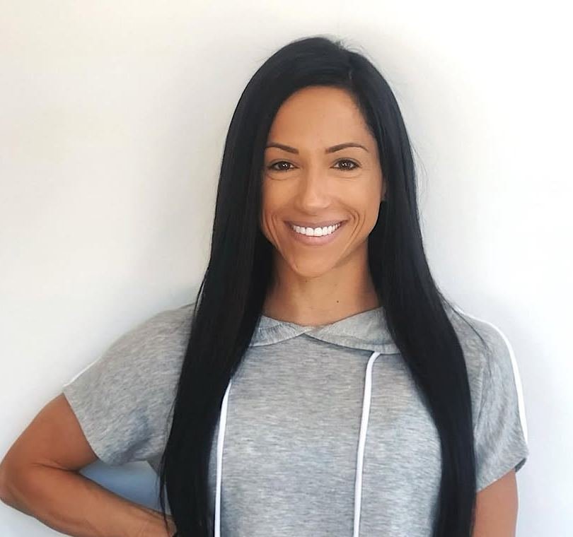 Woman with long, smooth, straight black hair smiling at the camera